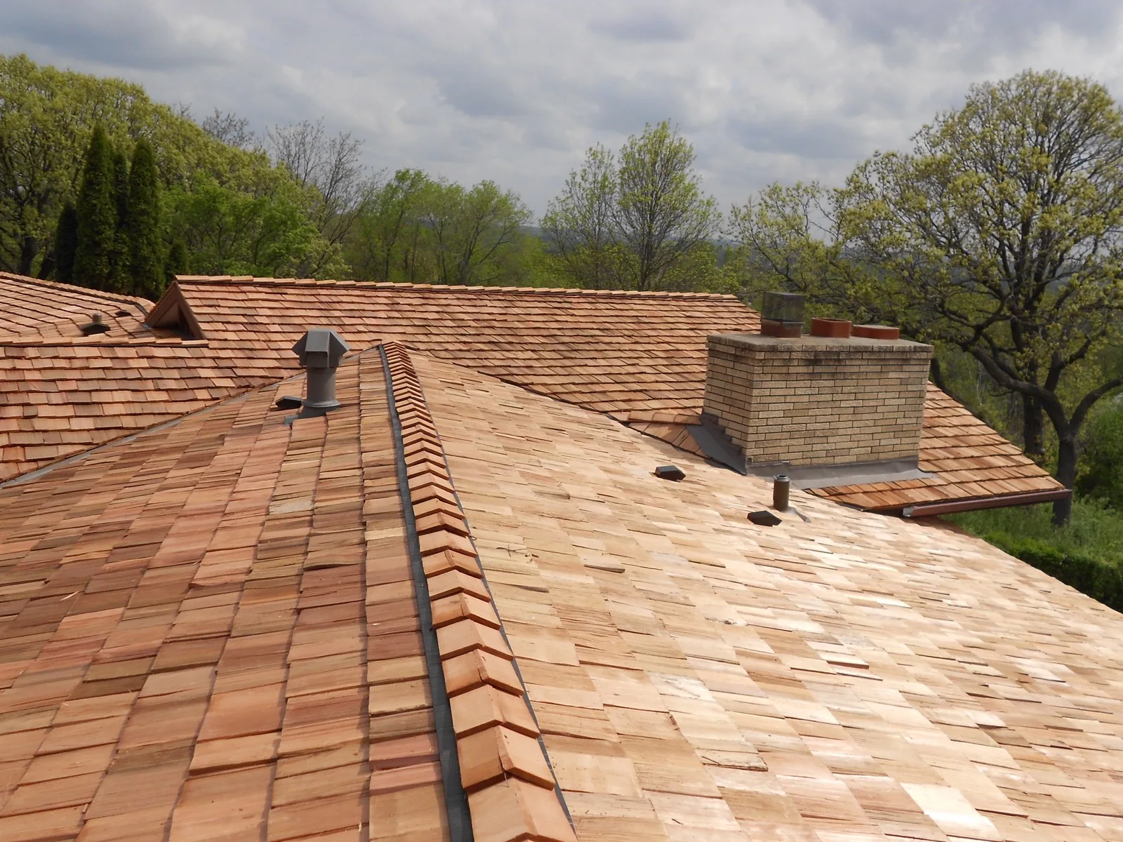 Cedar shake wood shingle roof installation with chimney flashing and valley metal detail. Northern Forge Construction specialty roofing in the north Minneapolis metro, MN