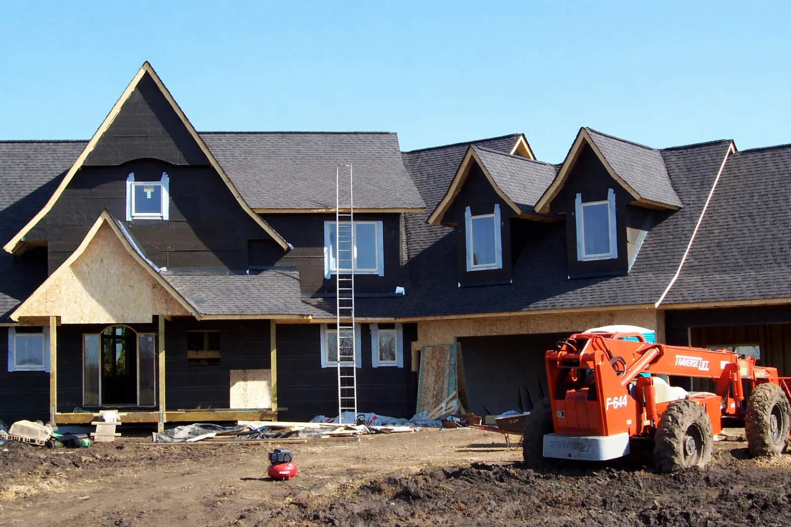 New custom home construction in Ham Lake, MN. Northern Forge Construction with boom lift and exterior framing in progress