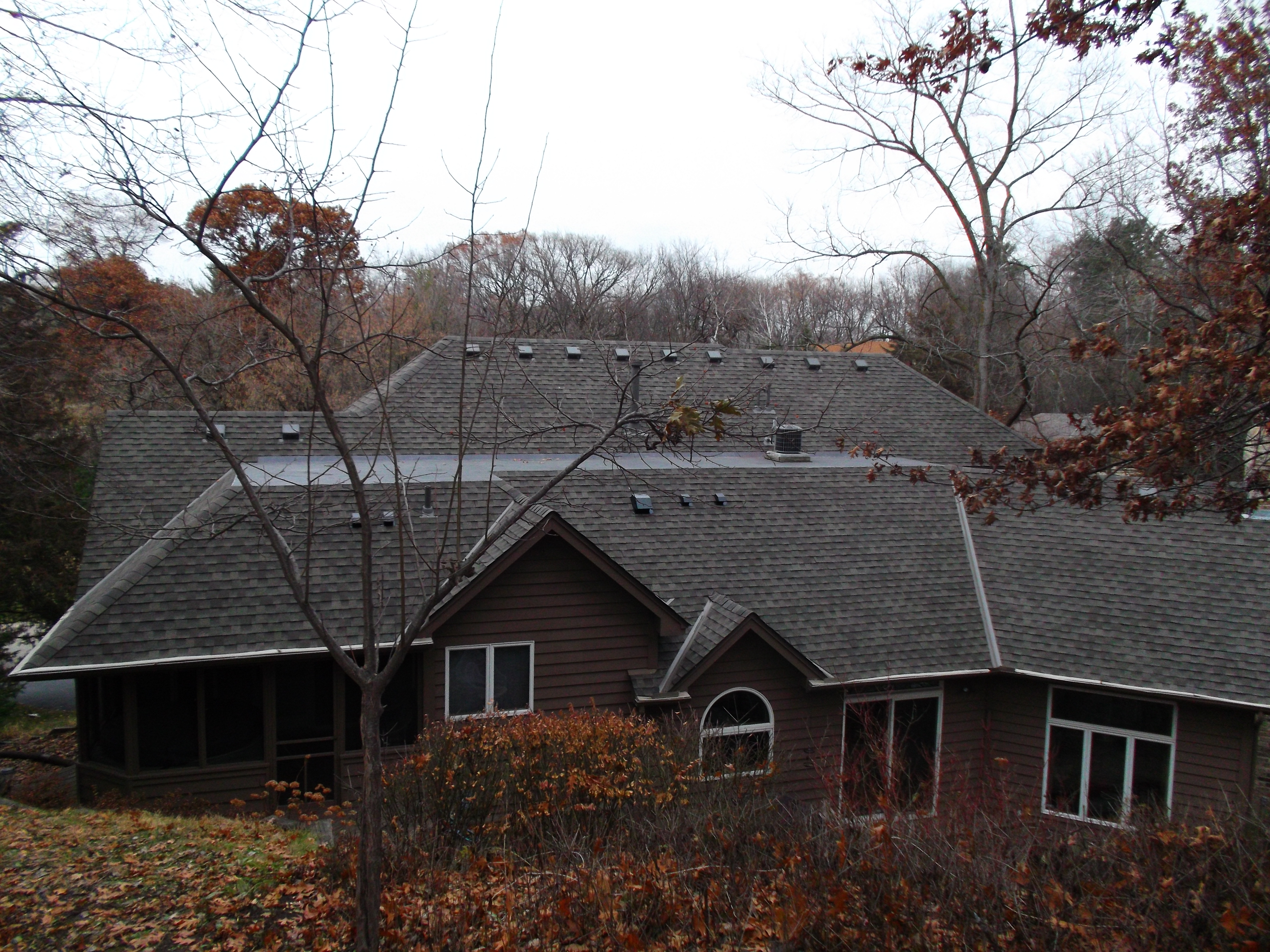 Large residential property with complex low-slope roofline in Ham Lake, MN — Northern Forge Construction flat and TPO roofing services in Anoka County and the north Minneapolis metro