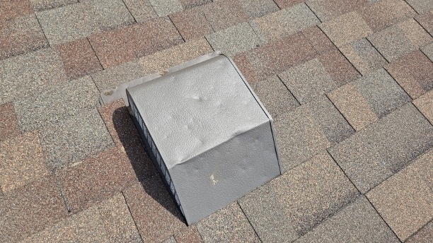 Dented roof vent and flashing from hail impact — insurance-documentable damage